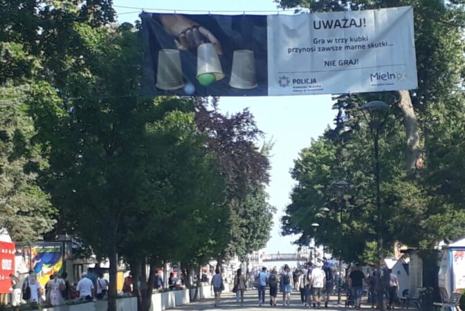 Gra w tzw. "trzy kubki". Oszuści szukają ofiar nad morzem